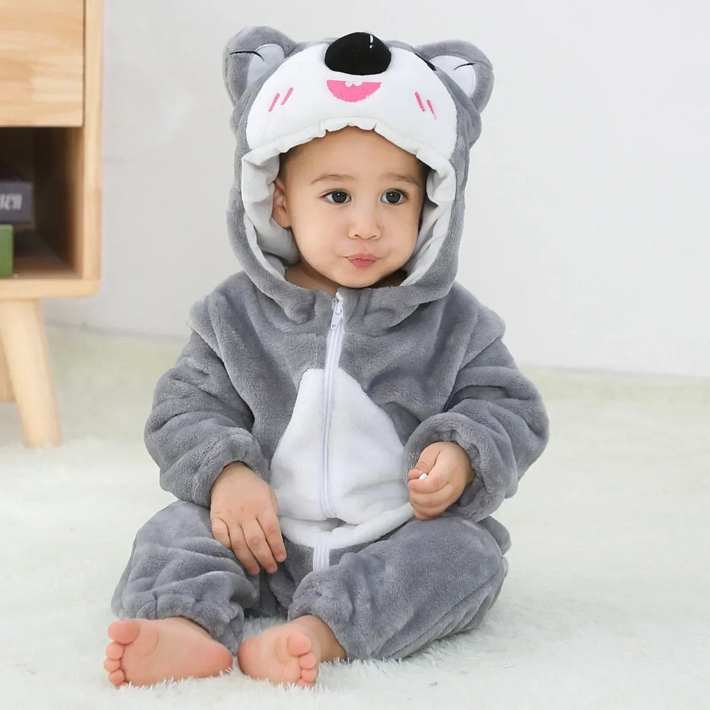 Child wearing a gray and white animal onesie with a hood on a light background