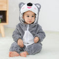 Child wearing a gray and white animal onesie with a hood on a light background