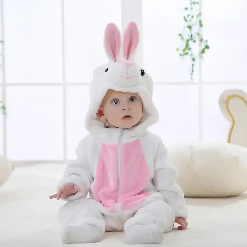 Baby in a bunny costume sitting on a white surface with a blurred background
